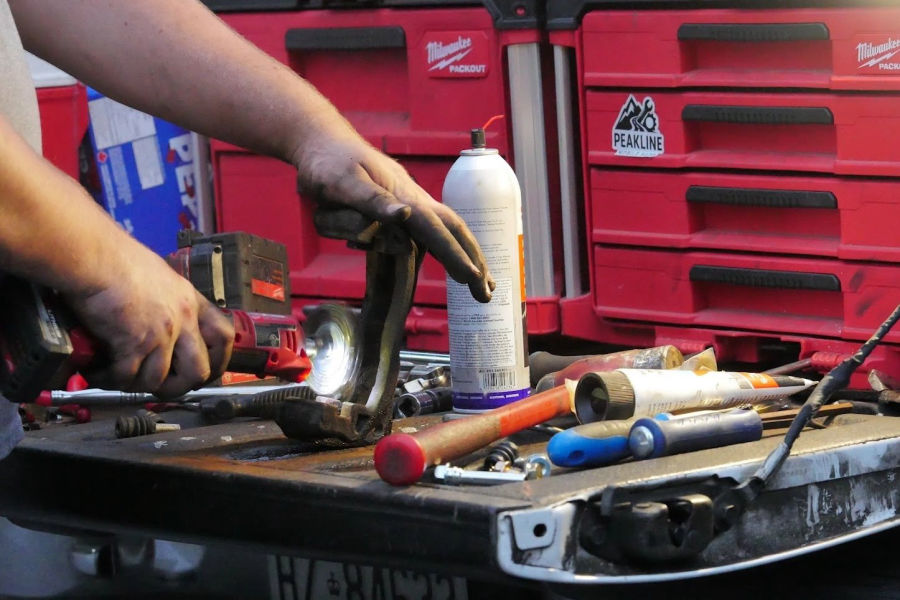 Tools laid out on a tailgate beside a Peakline-stickered tool chest